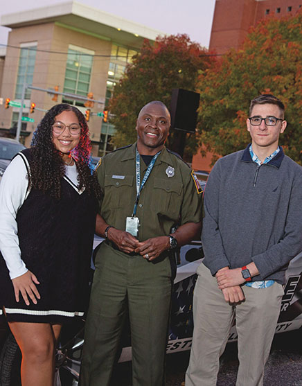 During the course, students Eva McDonnell (left) and Michael Kyrychenko (right) built dialogue and open discussion to explore policy solutions with officer Darryl Skinner of the Chesterfield County Police Department (center).