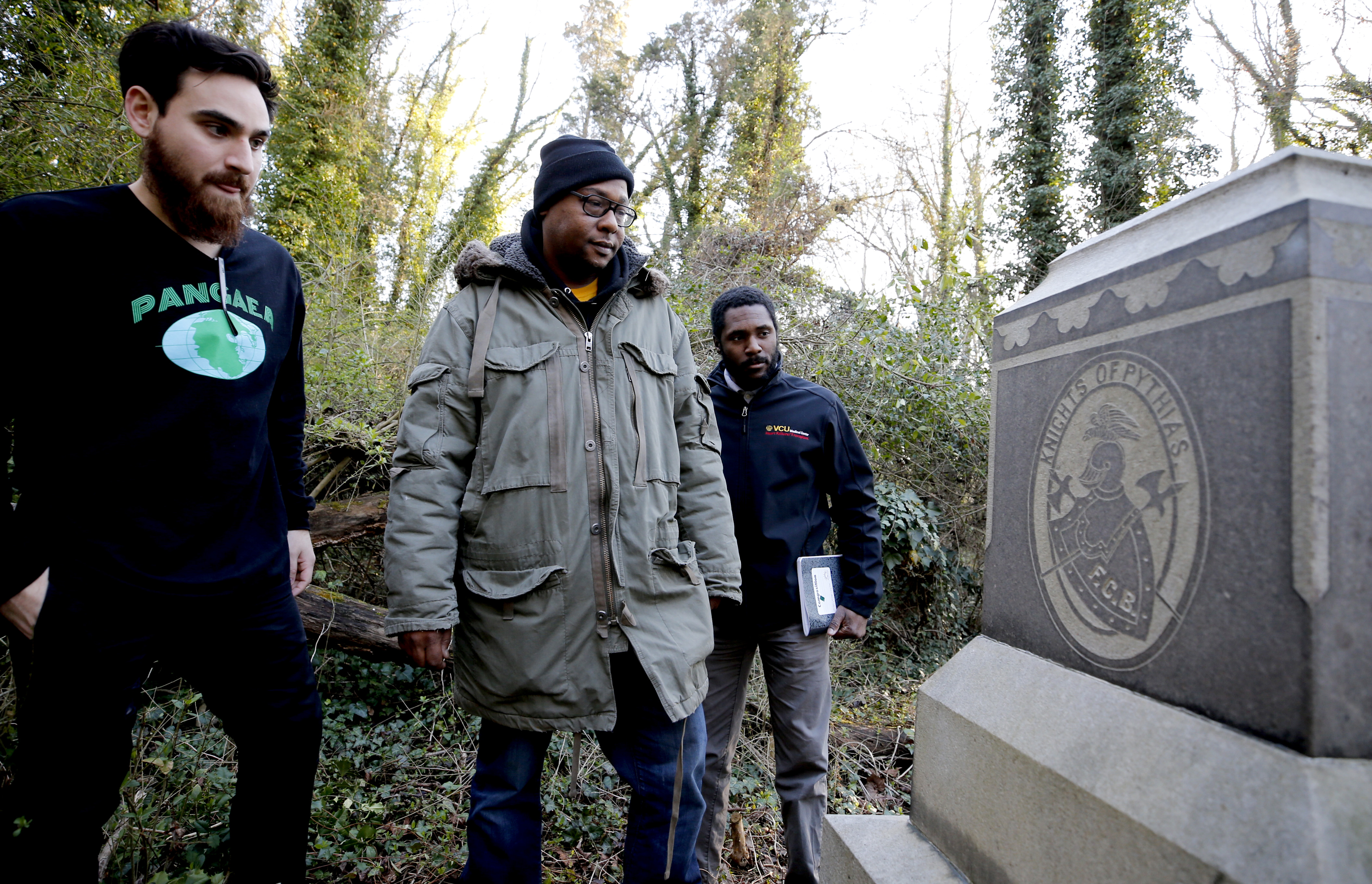 (Top) Wilder School students study a tombstone. (Middle) Assistant Professor Kathryn Howell, Ph.D., and students look to see what Evergreen Cemetery Caretaker Ted Maris-Wolf is uncovering. (Below) Wilder School students watch their steps as they walk through the cemetery's vine-clogged paths.