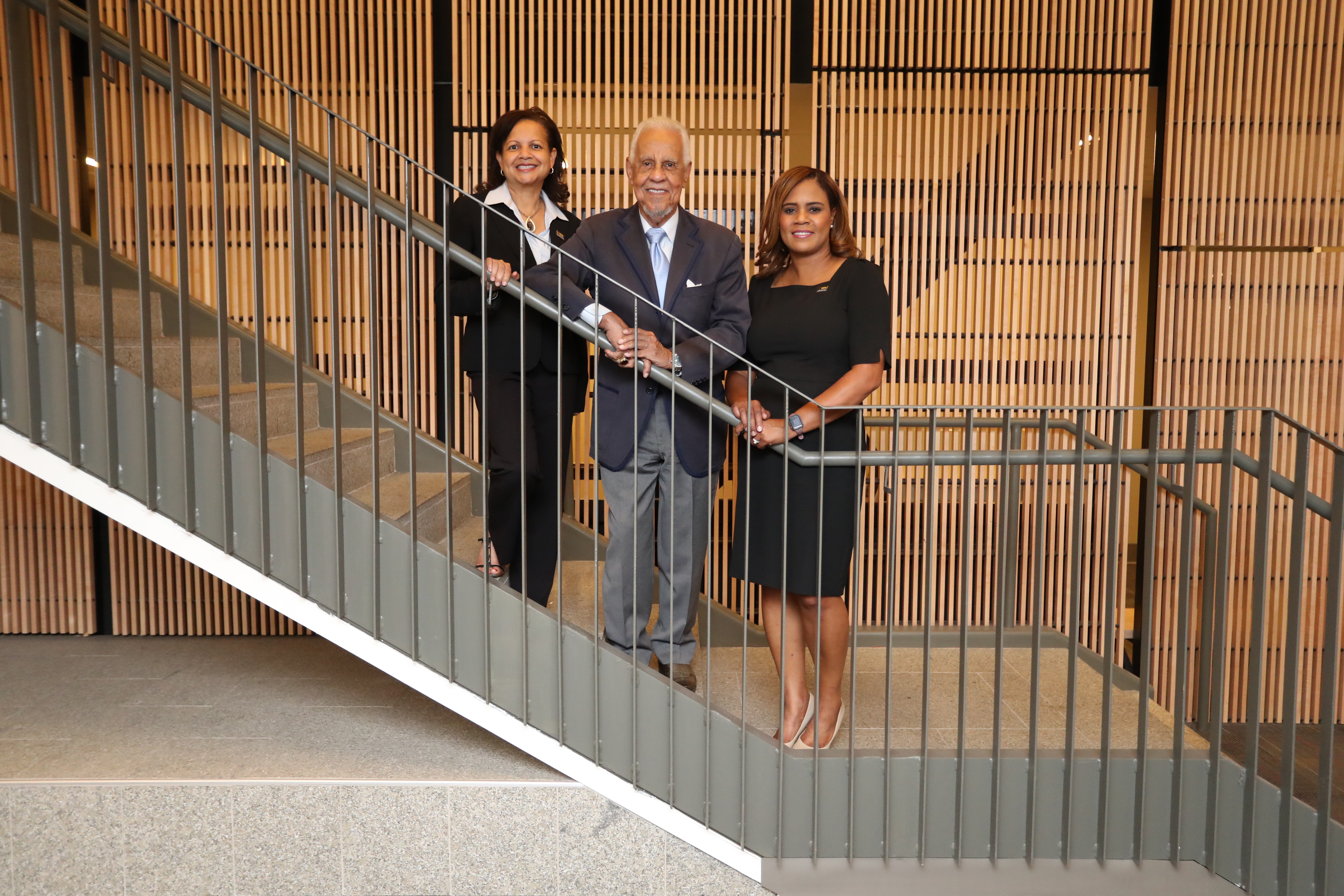 Three people standing on a staircase