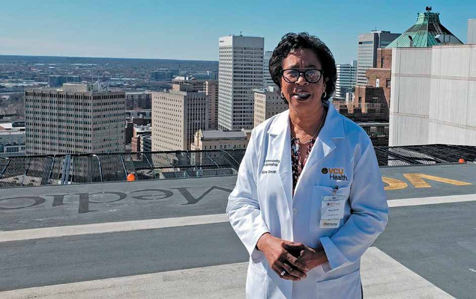 headshot of myra goodman smith standing on a rooftop in front of a city skyline