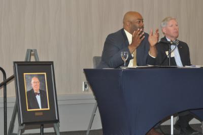 Dels. Lamont Bagby and Steve Lamont discuss education-related bills next to a portrait of the late Dr. William C. Bosher Jr. during the CEPI 2018 Legislative Conference.