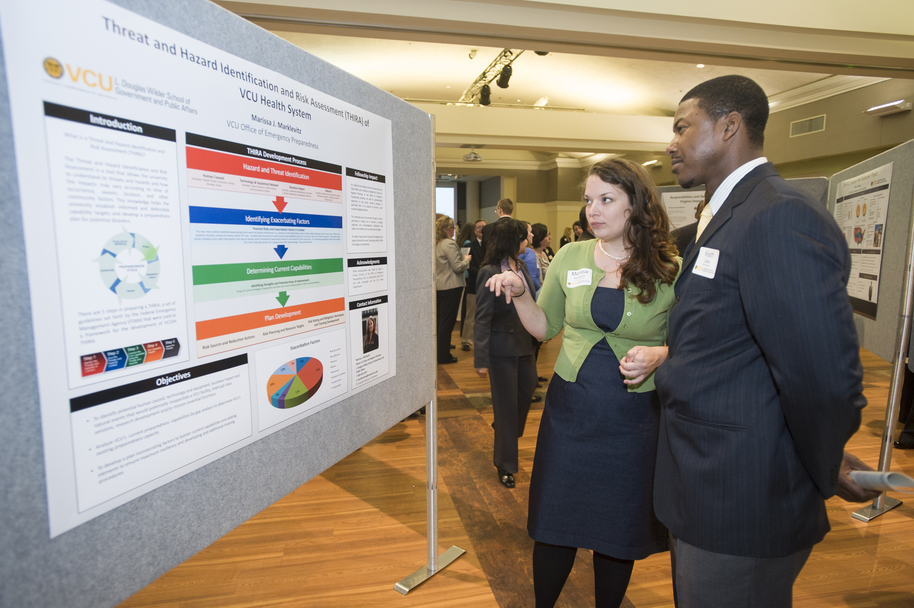 Students review research presentation board