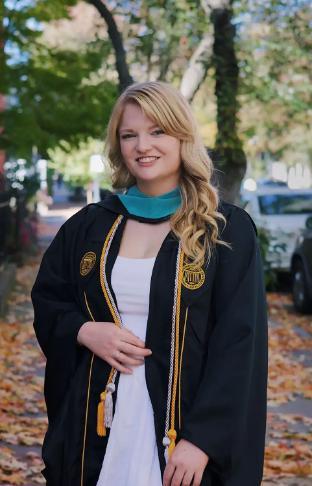 Ashley Van Buskirk poses in her graduation gown.