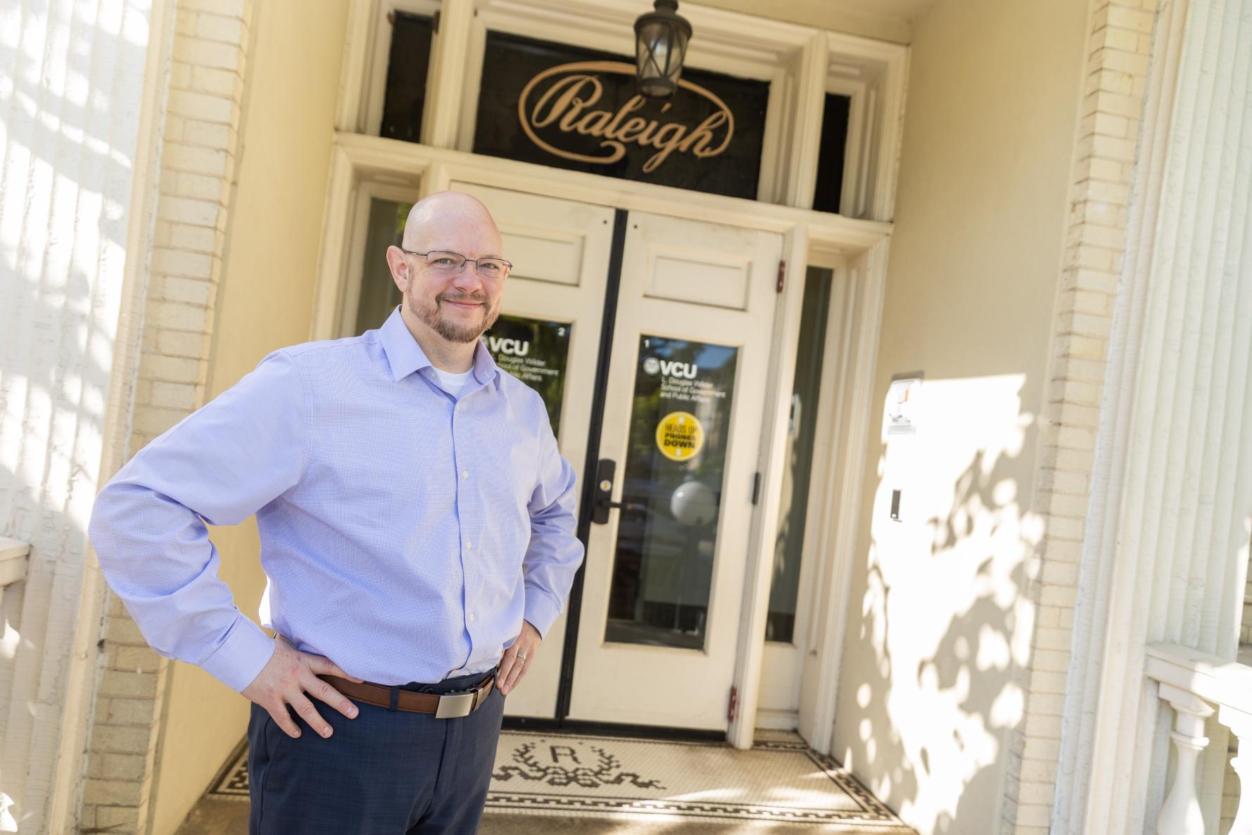 David Dearden poses in front of the Raleigh Building