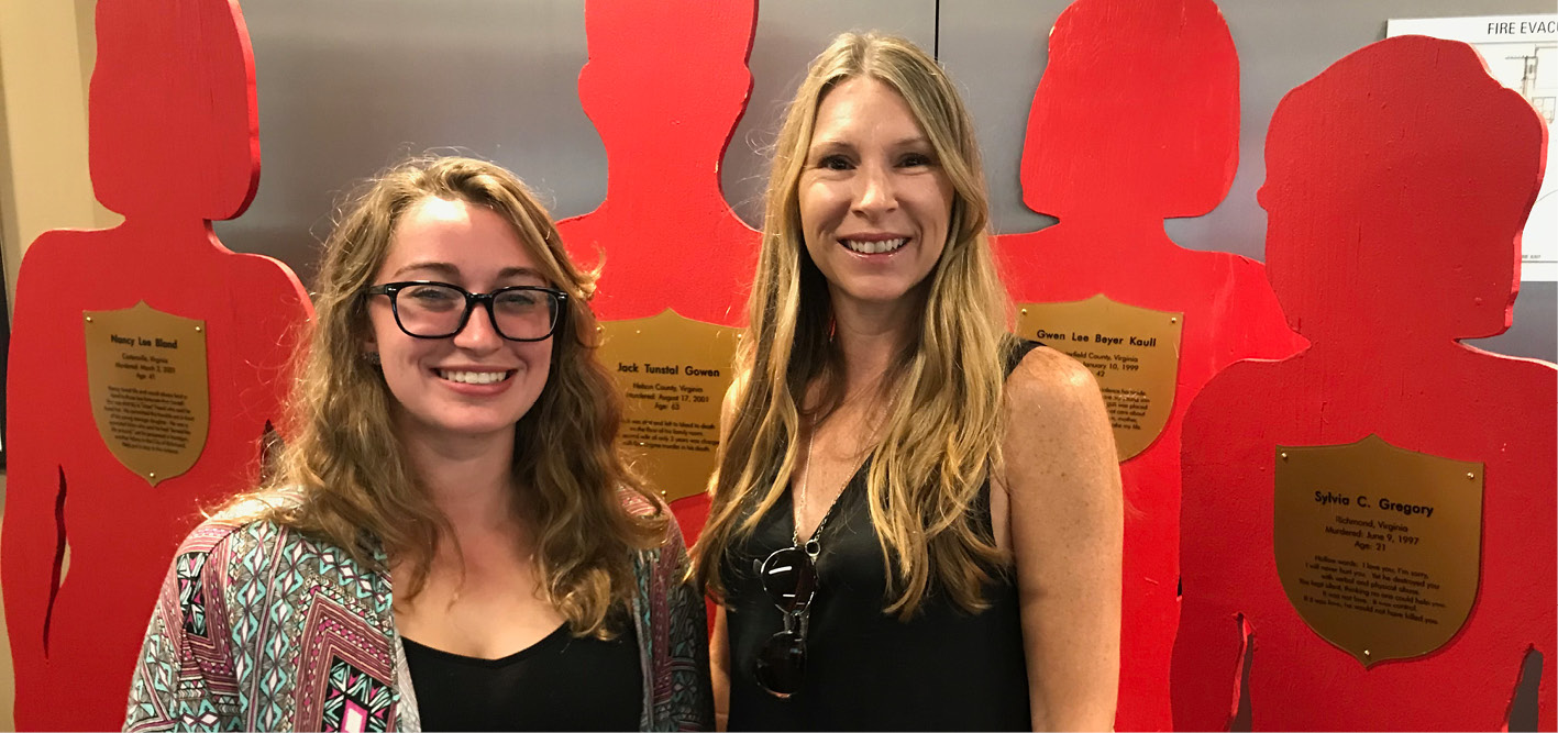 Silent Witness organizer Amy Cook, Ph.D., (right) chair of the Wilder School's Criminal Justice program, and student volunteer Roxanna Dodson stand next to some of the life-sized cutouts that visually represent the victims of intimate partner violence.