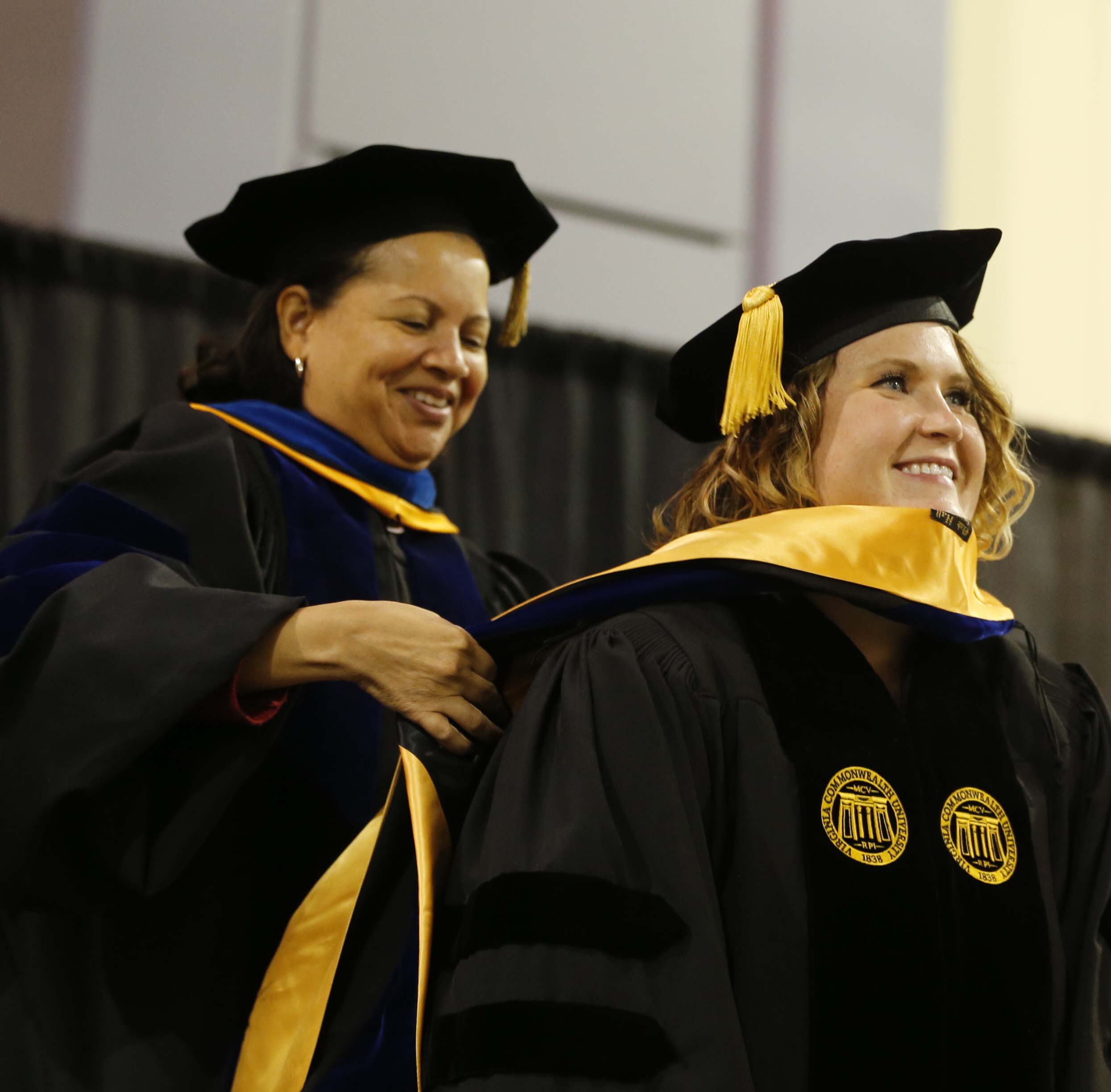 Dr. Susan Gooden presents Lindsey Evans with her hood during the Wilder School's doctoral hooding ceremony on December 9, 2017.
